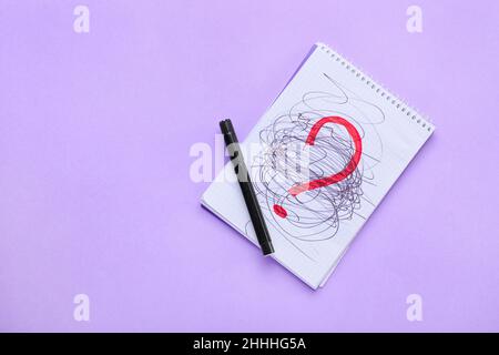 Notebook with question mark on purple background Stock Photo