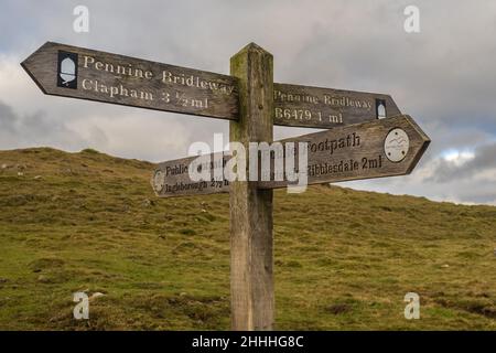 16.01.2022 Horton in Ribblesdale, North Yorkshire, UK  Fingerpost sign for hill walkers on the lower slopes of Ingleborough showing the way for the th Stock Photo