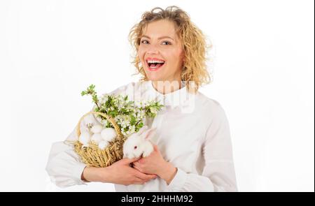 Smiling woman with rabbit and basket with eggs. Easter egg. Bunny. Happy Easters day. Stock Photo