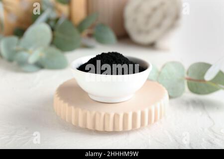 Bowl with activated charcoal tooth powder on table Stock Photo