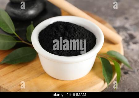 Bowl with activated charcoal tooth powder on table Stock Photo