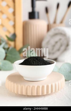 Bowl with activated charcoal tooth powder on table Stock Photo