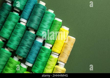 Spools with threads on green background Stock Photo
