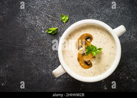 Mushroom Soup in craft bowl on dark stone table. Stock Photo