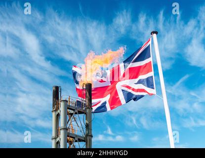 Industrial gas flare stack/chimney and Union Jack flag. Rising energy prices, cost of living, global warming, climate change, net zero... concept Stock Photo