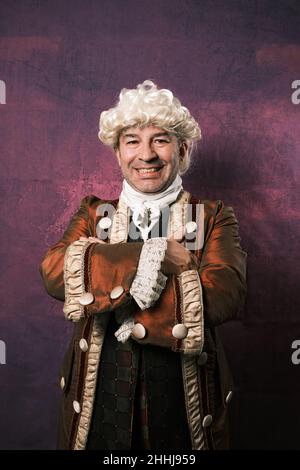 Adult man in classical medieval clothing posing with his arms crossed on an isolated background. Stock Photo