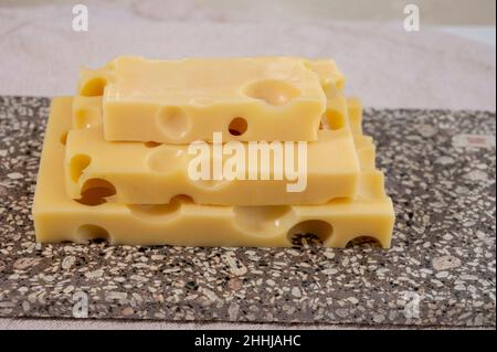 Cheese collection, semi-hard French cheese emmentaler with round holes made from cow milk close up Stock Photo