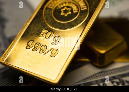 Close-up of gold ingots on top of US dollar banknotes Stock Photo