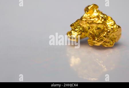 Close-up of a gold-nugget on a white background Stock Photo