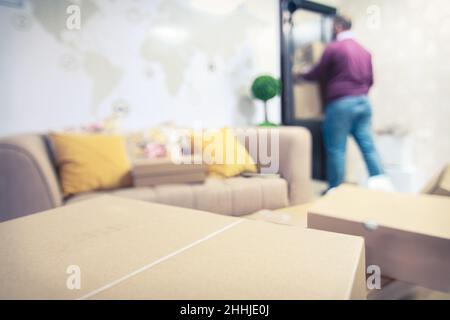 Cardboard box with delivery man carrying boxes in a shipping warehouse mockup with copyspace Stock Photo