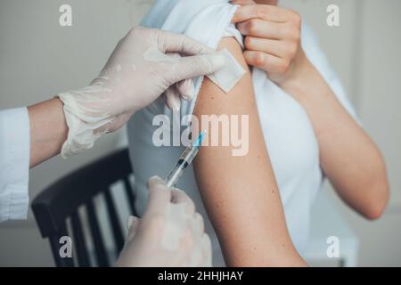 Closeup portrait of doctor's hands giving injection to patient's arm at hospital. Pandemic prevention. Coronavirus safety. Health care. Stock Photo