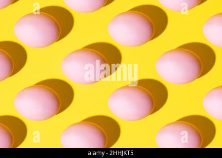 Pink eggs pattern on a yellow background Stock Photo