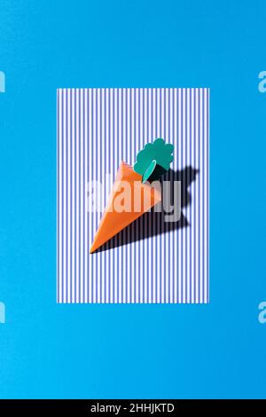 A cardboard carrot on a blue background Stock Photo
