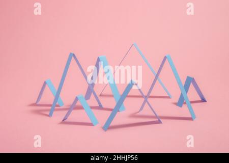 Creative abstract geometric Zig Zags lines arranged in chart pattern placed on pink background with shadow in light modern studio Stock Photo