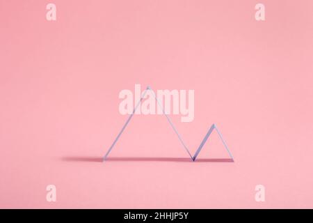 Creative abstract geometric Zig Zags lines arranged in chart pattern placed on pink background with shadow in light modern studio Stock Photo