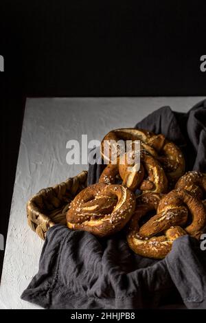 From above of appetizing homemade pretzel pastries on wicker tray with napkin placed on table Stock Photo