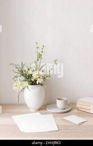 Floral still life. Easter bouquet. Wite, yellow tulips, daffodils flowers. Green birch tree, blueberry branches in ceramic vase pot on wooden table Stock Photo