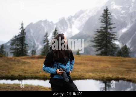 Crop anonymous female in white shirt with stack of blue jeans in hands Stock Photo