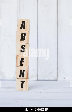 wooden cube with the word absent, on white wooden background Stock Photo