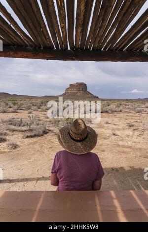 USA, New Mexico, Chaco Canyon National Historic Park, Rear view of woman in straw hat looking at Fajada Butte in Chaco Canyon in Chaco Culture National Historical Park Stock Photo