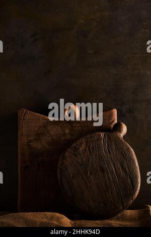 Handmade wooden chopping board of brown color placed on rustic table Stock Photo