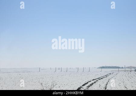 Picture of a typical winter landscape, a rural agricultural field covered with snow and ice in the region of Banat, in Serbia, in Europe. Stock Photo