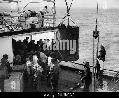 Passengers come aboard in basket owing to sea being too rough for use of companion ladder. Rough sea at Port Elizabeth. SS Llandovery Castle. 16th April 1928. Stock Photo