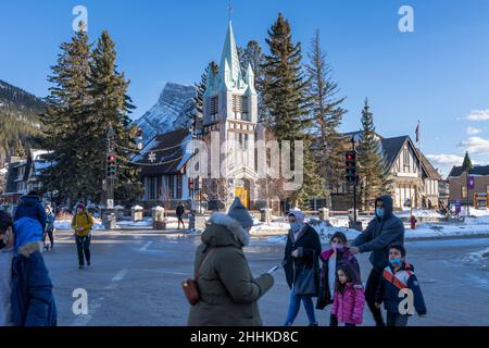 Banff, Alberta, Canada - January 23 2022 : Downtown Banff Avenue in winter. Pedestrians are crossing the road during covid-19 pandemic period. Stock Photo