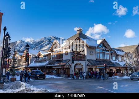 Banff, Alberta, Canada - January 23 2022 : Downtown Banff Avenue in winter. Pedestrians are crossing the road during covid-19 pandemic period. Stock Photo