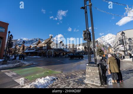 Banff, Alberta, Canada - January 23 2022 : Downtown Banff Avenue in winter. Pedestrians are crossing the road during covid-19 pandemic period. Stock Photo