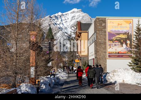 Banff, Alberta, Canada - January 23 2022 : Tourists shopping on Banff Avenue in winter during covid-19 pandemic period. Stock Photo