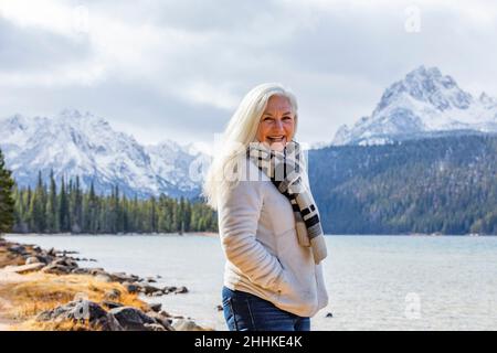 USA, Idaho, Stanley, Portrait of smiling senior woman at mountain lake Stock Photo