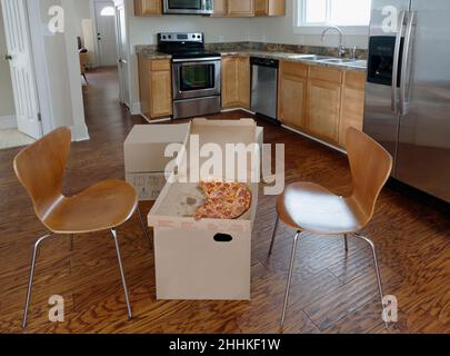 Pizza break on cardboard boxes during house move Stock Photo