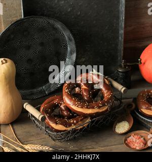 German Brezel Pretzel with Sesame Seed on Rustic Wooden Background Stock Photo