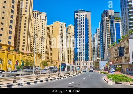 DUBAI, UAE - MARCH 7, 2020: The modern tram rides along the street, lined with skyscrapers of Dubai Marina, on March 7 in Dubai Stock Photo