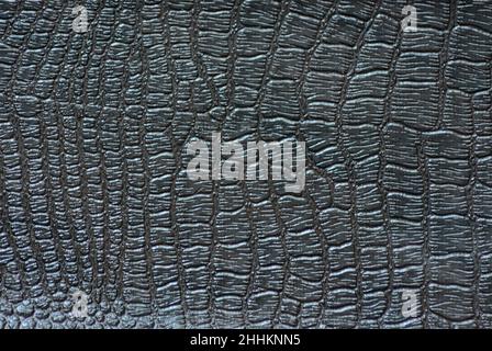 Black reptile skin, scaly pattern with polished sheen close-up. Background, pattern, texture. Stock Photo