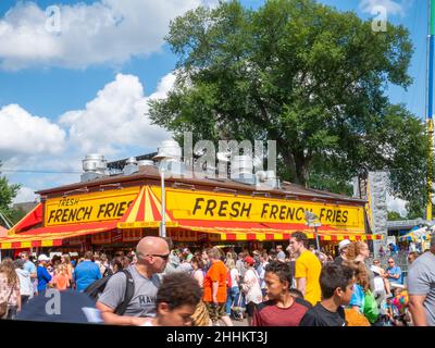 FALCON HEIGHTS, MN - 23 AUG 2019: State Fair French Fries food booth with crowds of people enoying themselves at the largest annual even in Minnesota. Stock Photo