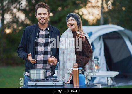 Young nice couple having fun on camping while cooking and eating Stock Photo