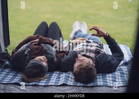 Young nice couple having fun on camping lying in tent Stock Photo