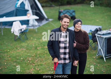Young nice couple having fun on camping with dog Stock Photo
