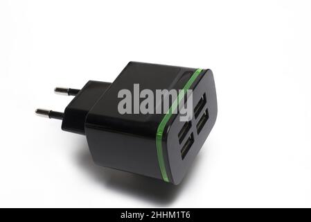 Close up of black EU plug adapter with four USB ports for cell phone charging on white background Stock Photo