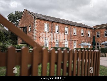 Historic old red brick mill warehouse building and gateway leading into the courtyard. Stock Photo