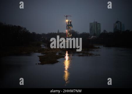 Magdeburg, Germany. 25th Jan, 2022. The morning dawns over the construction site of the replacement Strombrückzug, whose lights are reflected in the Old Elbe. As in previous days, the day remains cloudy and dry. Credit: Klaus-Dietmar Gabbert/dpa-Zentralbild/ZB/dpa/Alamy Live News Stock Photo