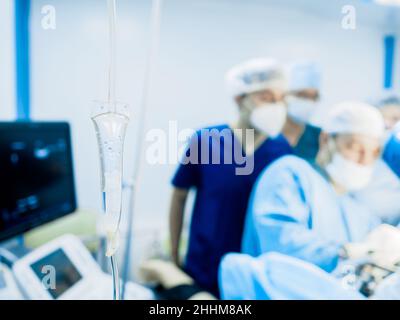 Selective focus on a transparent tube of a medical dropper with saline close-up. On a blurred background, surgery. Stock Photo