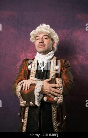 Serious man in classic renaissance clothes posing over an isolated background. Stock Photo