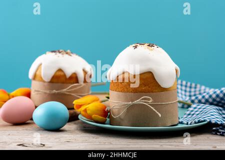 Traditional Easter cake, colorful eggs and tulips on wooden table Stock Photo