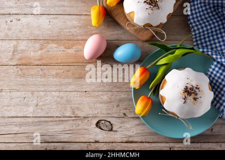 Traditional Easter cake, colorful eggs and tulips on wooden table Stock Photo
