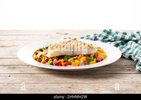 Grilled cod with vegetables in plate on wooden table Stock Photo