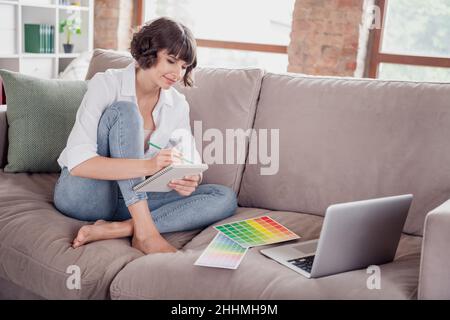 Full length body size photo female graphic designer drawing in blocknote near laptop color palettes Stock Photo