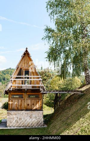 A small triangular wooden house in the middle of the forest Stock Photo ...